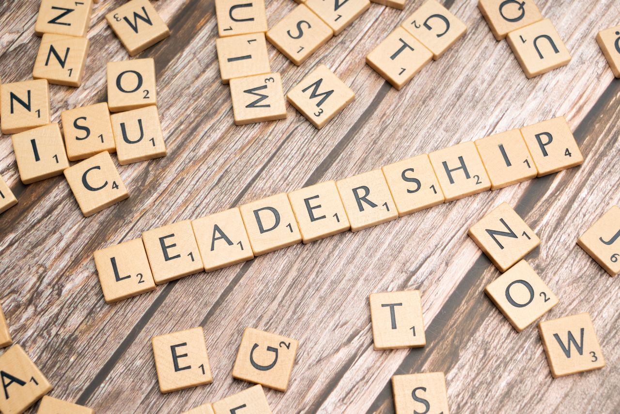 Letter tiles in wood forming the word LEADERSHIP on a wooden background, representing leadership qualities and skills.
